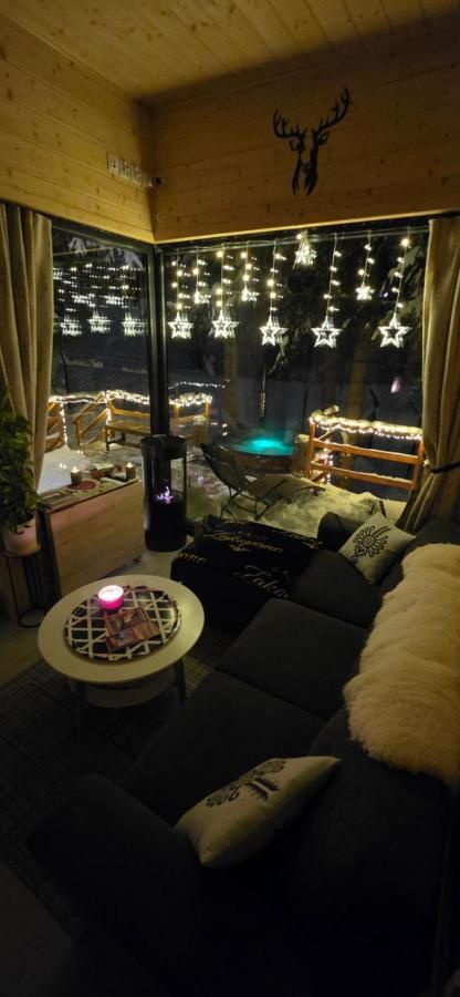 Salon wieczorem, za szybą lampki i podświetlone jacuzzi
